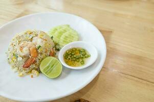 Prawn fried rice on white plate on wooden table background photo