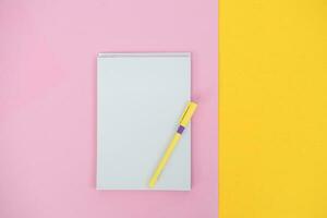 A notebook for writing on a colored background with a pen. Copy space photo