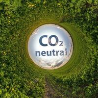 co2 neutral texto concepto imagen en contra azul pequeño planeta en verde césped antecedentes foto