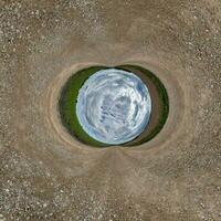 blue sphere little planet inside gravel road or field background. curvature of space photo