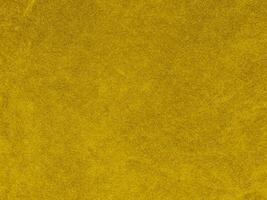 textura de tela de terciopelo amarillo utilizada como fondo. fondo de tela amarilla vacía de material textil suave y liso. hay espacio para el texto. foto