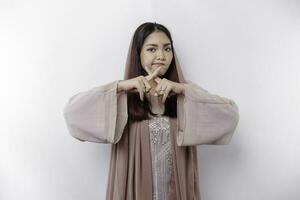 Beautiful Asian Muslim woman wearing a hijab with hand gesture pose rejection or prohibition with copy space photo