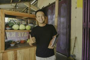 Handsome Asian Man is smiling while checking his satay kiosk photo