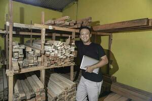 Handsome Asian Man is smiling while checking his carpentry workshop photo