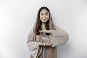 Young Asian Muslim woman over isolated background holding copy space imaginary on the palm to insert an ad photo