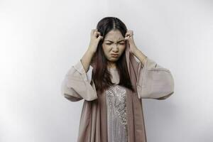 A portrait of an Asian Muslim woman wearing a headscarf isolated by white background looks depressed photo