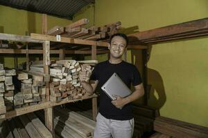 Handsome Asian Man is smiling while checking his carpentry workshop photo