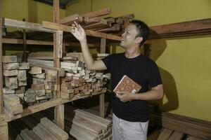 Handsome Asian Man is smiling while checking his carpentry workshop photo
