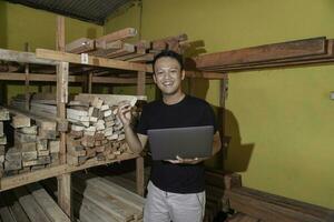 Handsome Asian Man is smiling while checking his carpentry workshop photo