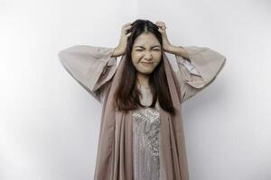 A portrait of an Asian Muslim woman wearing a headscarf isolated by white background looks depressed photo