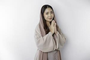 religioso hermosa asiático musulmán niña vistiendo un Pañuelo Orando a dios, aislado por blanco antecedentes foto