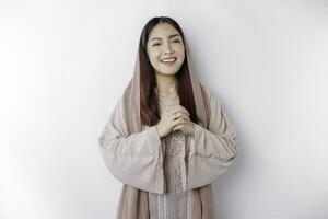 Portrait of a young beautiful Asian Muslim woman wearing a headscarf gesturing Eid Mubarak greeting photo