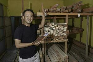 Handsome Asian Man is smiling while checking his carpentry workshop photo