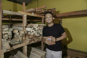 Handsome Asian Man is smiling while checking his carpentry workshop photo