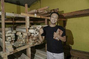 Handsome Asian Man is smiling while checking his carpentry workshop photo
