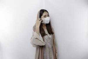 A cautious Asian Muslim woman wearing a mask as a preventive for covid-19 photo