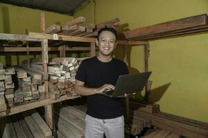 Handsome Asian Man is smiling while checking his carpentry workshop photo