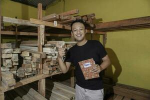 Handsome Asian Man is smiling while checking his carpentry workshop photo