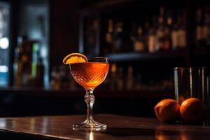 A cocktail glass with an orange slice on top cocktail on a bar counter. photo