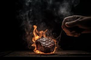 An iron k holding a medium rare steak on a dark background sparks and fire coming up from below fire and meat. photo