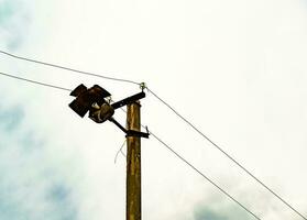 Poste eléctrico de potencia con cable de línea sobre fondo de color cerrar foto