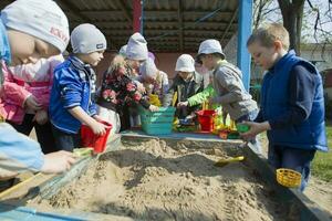 Belarus, Gomel, May 30, 2019. An open day in a kindergarten. A group of children from kindergarten play in the sandbox. photo