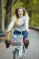 joven hermosa mujer paseos un bicicleta en el otoño parque. foto