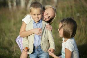 contento familia hermanas y pequeño hermano en un verano prado. foto