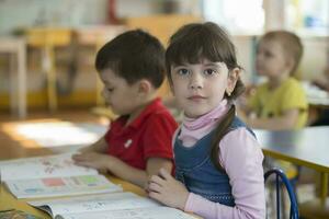 Preschoolers at school desks in kindergarten. photo