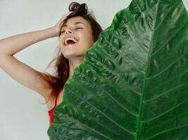 woman with red hair holds green palm leaf in her hand photo