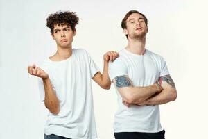 two men in white t-shirts are standing side by side isolated background photo