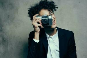 photographer with a camera in a classic suit curly hair Studio Model photo