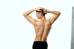 man athlete in shorts holding hands behind head back view fitness photo