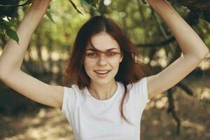 bonito mujer cerca un árbol al aire libre en el bosque Fresco aire y viaje foto