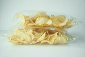 tasty potato chips in a packet on white background photo