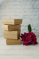 stack of gift box and rose flower on table photo