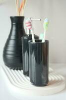 Tooth brushes in glass on table photo