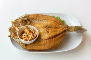 Deep fried sea bass or Fried snapper with fish sauce and spicy mango salad. photo