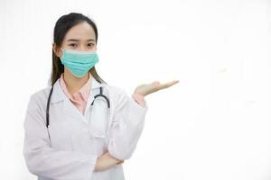 profesional asiático mujer médico usa médico cara máscara a proteger coronavirus o codicioso 19 o patógeno y polvo en salud cuidado concepto y muestra mano arriba en blanco antecedentes. foto