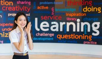 Portrait of adult Thai student. Beautiful Asian young woman student in uniform is smiling and looking at camera to present something confidently in the university. photo