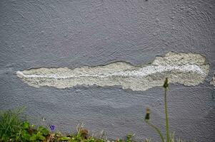 Crack in a house wall with chipped paint photo