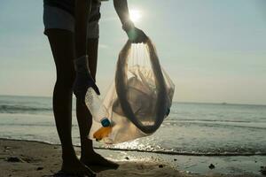 Save water. Volunteer pick up trash garbage at the beach and plastic bottles are difficult decompose prevent harm aquatic life. Earth, Environment, Greening planet, reduce global warming, Save world photo