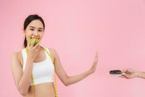 Delgado cuerpo mujer escoger durante verde manzana y chocolate rosquilla, hembra escoger verde manzana para dieta. bueno sano alimento. peso perder, balance, control, reducir gordo, bajo calorías, rutinas, ejercicio. foto