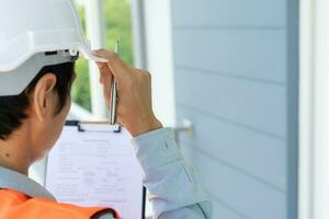 inspector or engineer is inspecting construction and quality assurance new house using a checklist. Engineers or architects or contactor work to build the house before handing it over to the homeowner photo