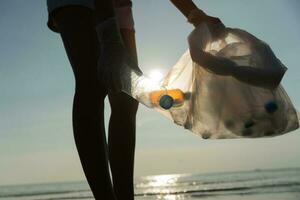 Save water. Volunteer pick up trash garbage at the beach and plastic bottles are difficult decompose prevent harm aquatic life. Earth, Environment, Greening planet, reduce global warming, Save world photo