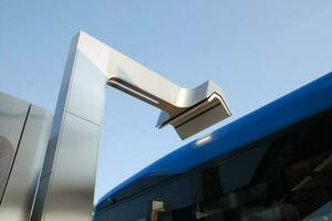 Charger for electric buses in process of charging battery on the roof of the bus, closeup photo