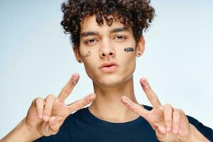 handsome man with curly hair black cosmetics hand gesture photo