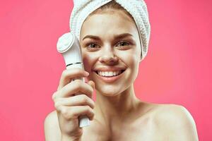 cheerful woman with bare shoulders facial cleansing photo