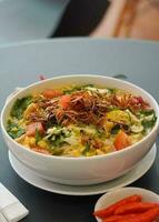 Traditional boiled noodles in a bowl with vegetables photo