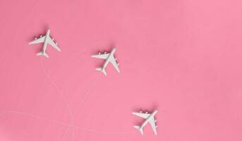 Aircraft travelling to different destinations on pink background with space for text. photo